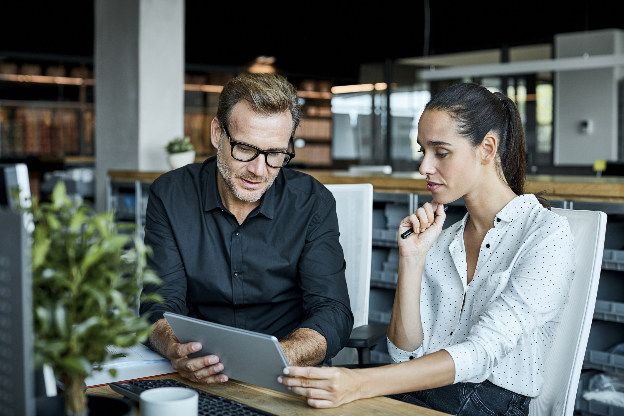Two people look at Quickbase on an iPad